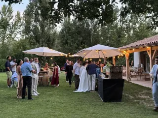 Terrasse couverte du domaine au soir, éclairée pour une réception