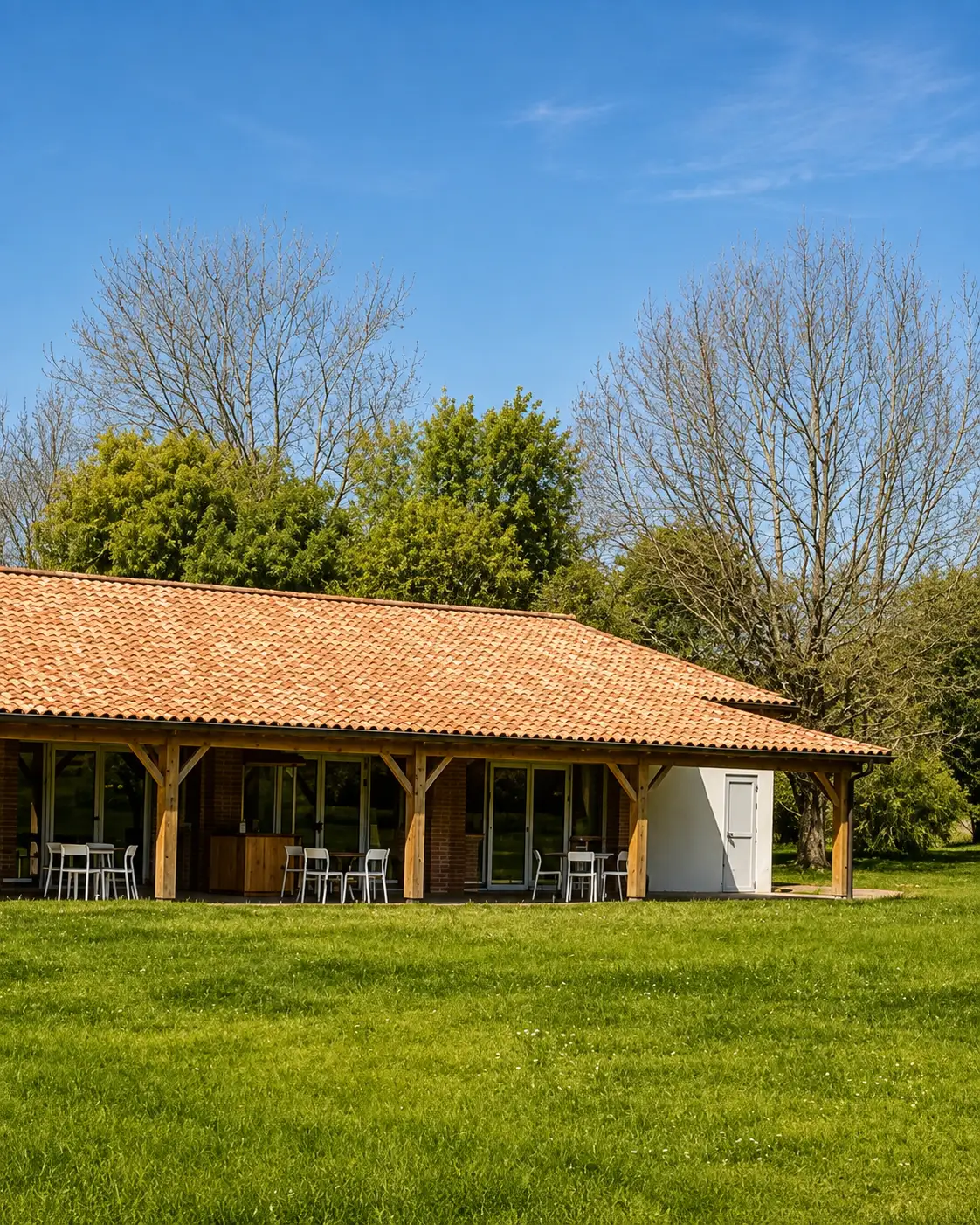 Façade en briquettes rouges de la salle de réception des Lauriers de la Bastide, ouverte sur le parc